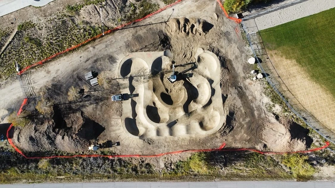 An overhead view shows the layout of the pump track during construction.