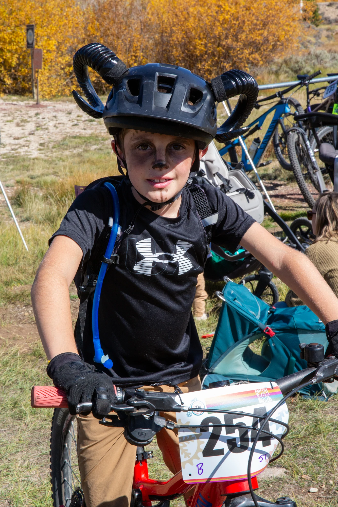 Young rider standing with a bike.